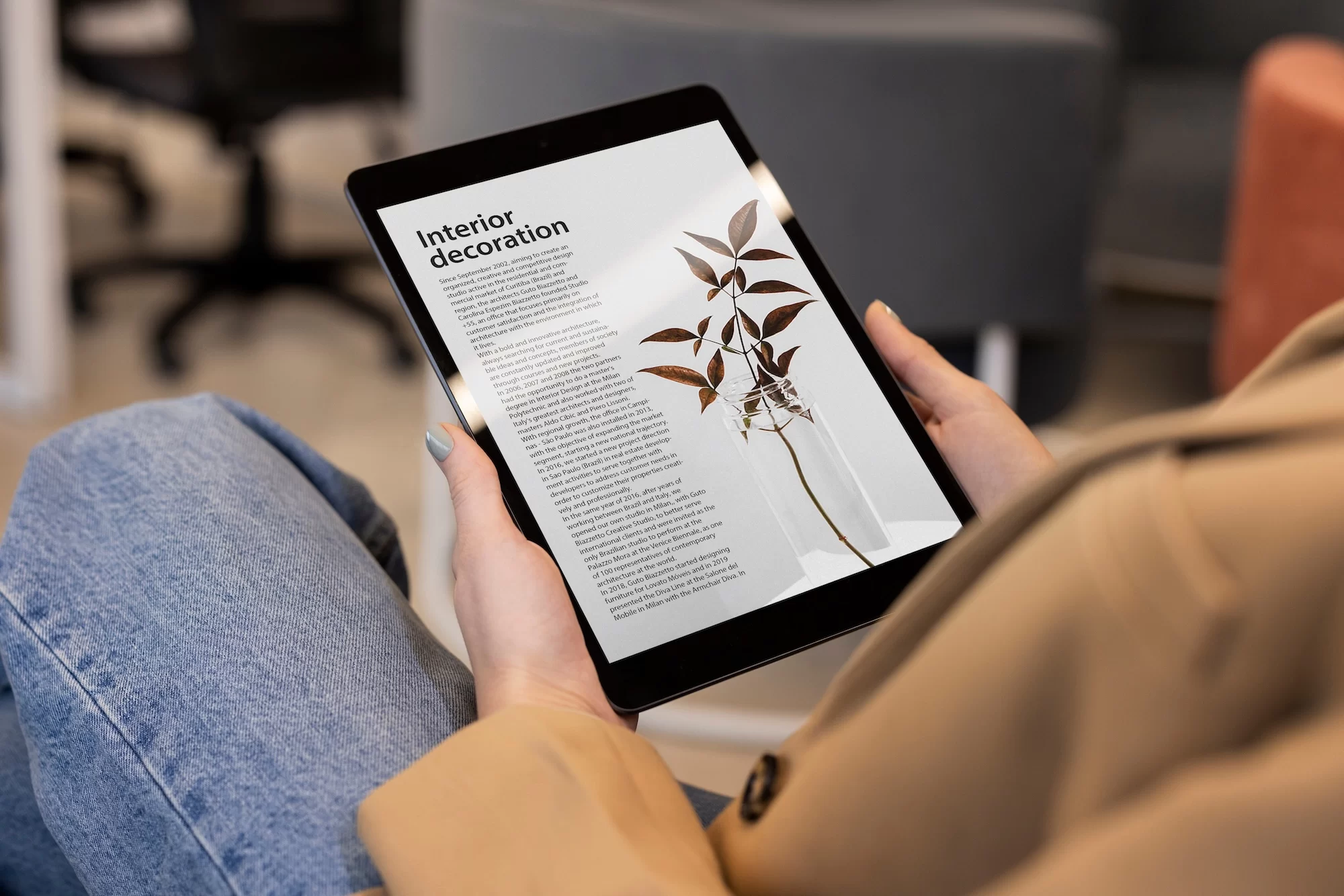 Person reading interior decoration article on tablet while relaxing at home on couch